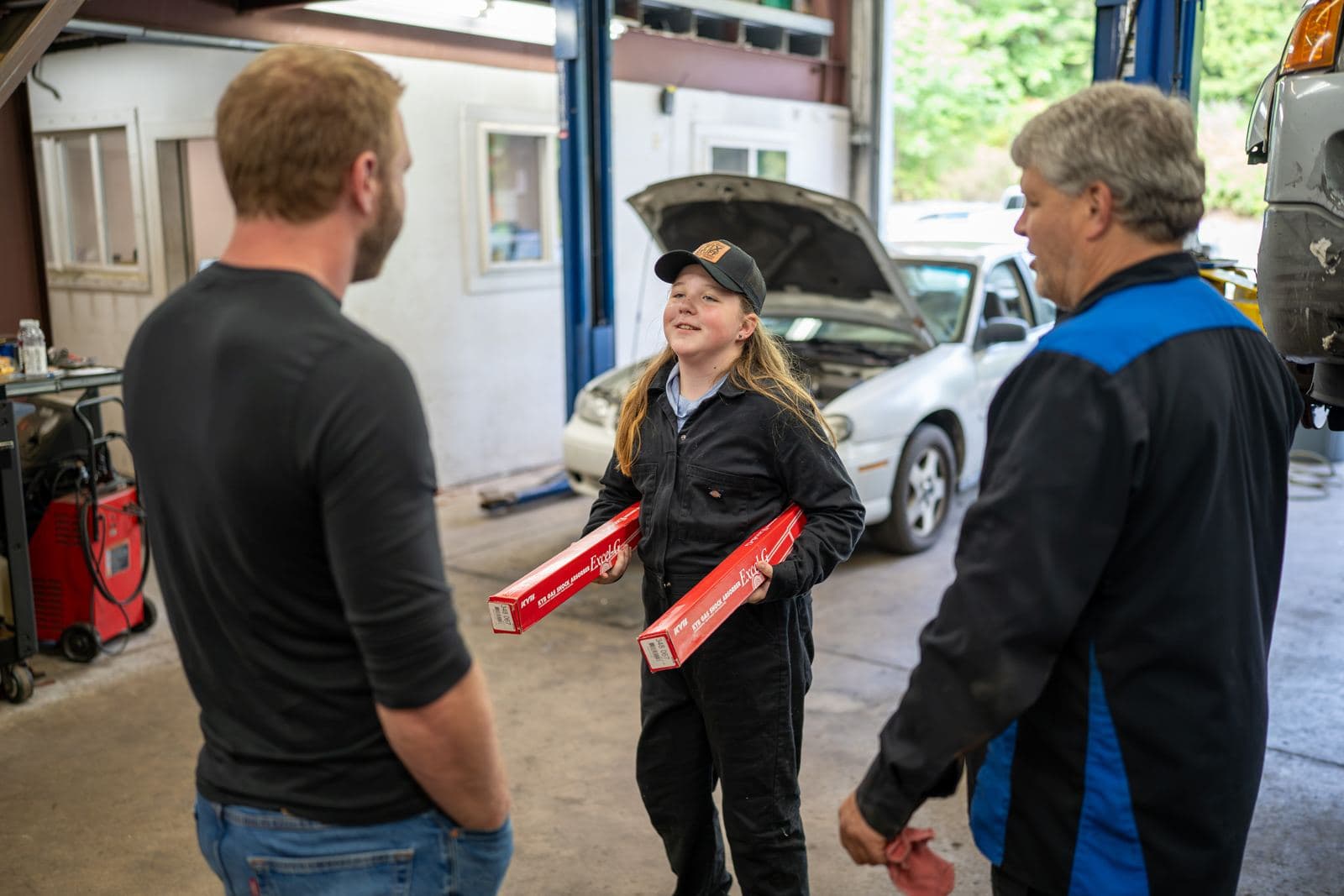 Shop owner talking with two technicians in the service bay