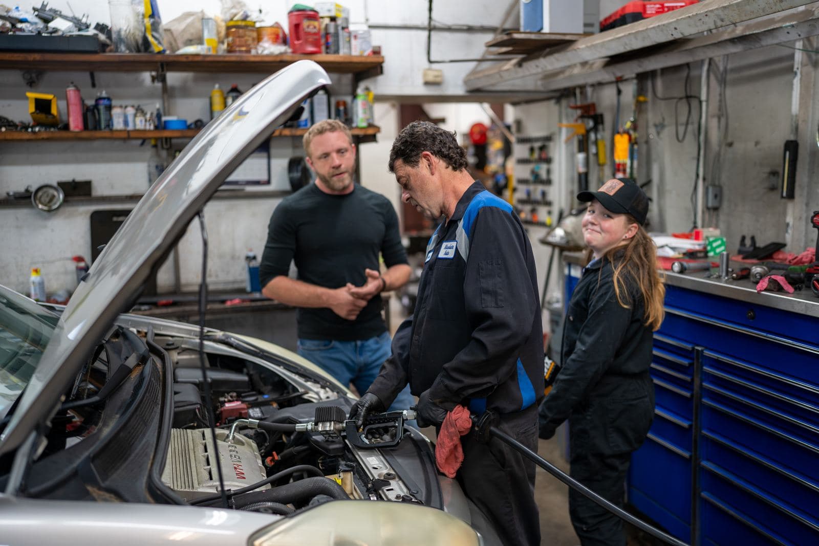 Technicians diagnosing a minivan engine with the hood up