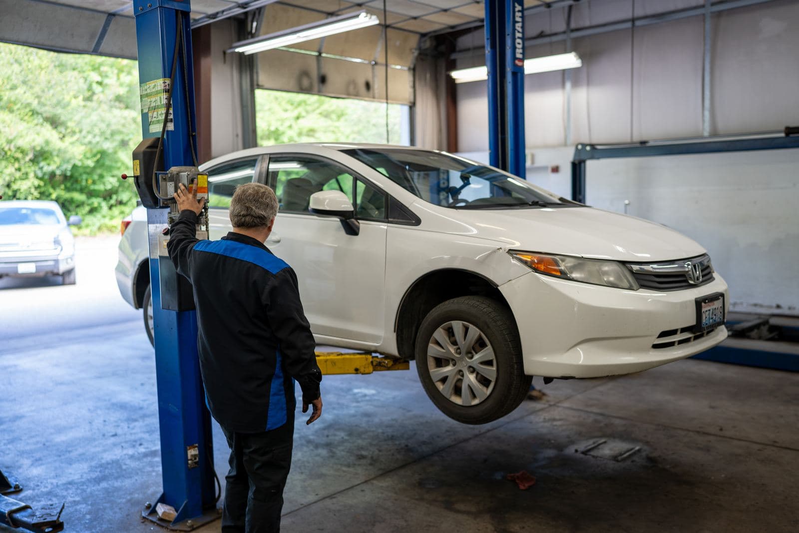 Technician raising a Honda Civic on the lift