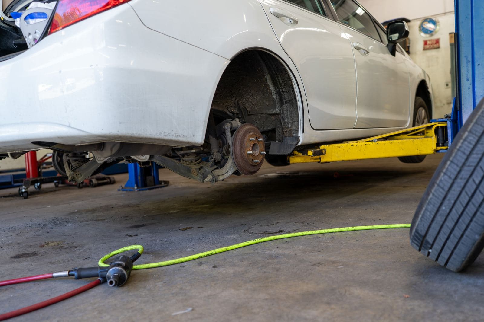 Car raised on the lift with a wheel removed for brake service