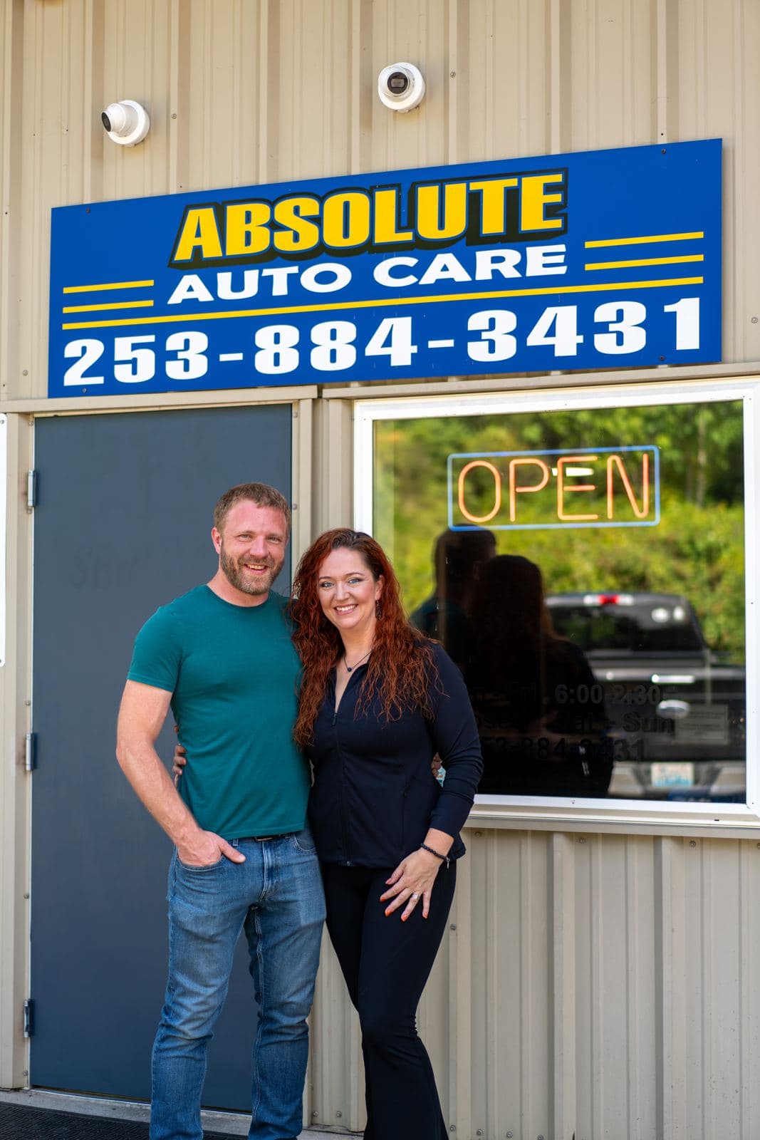 The Absolute Auto Care family in front of the shop sign