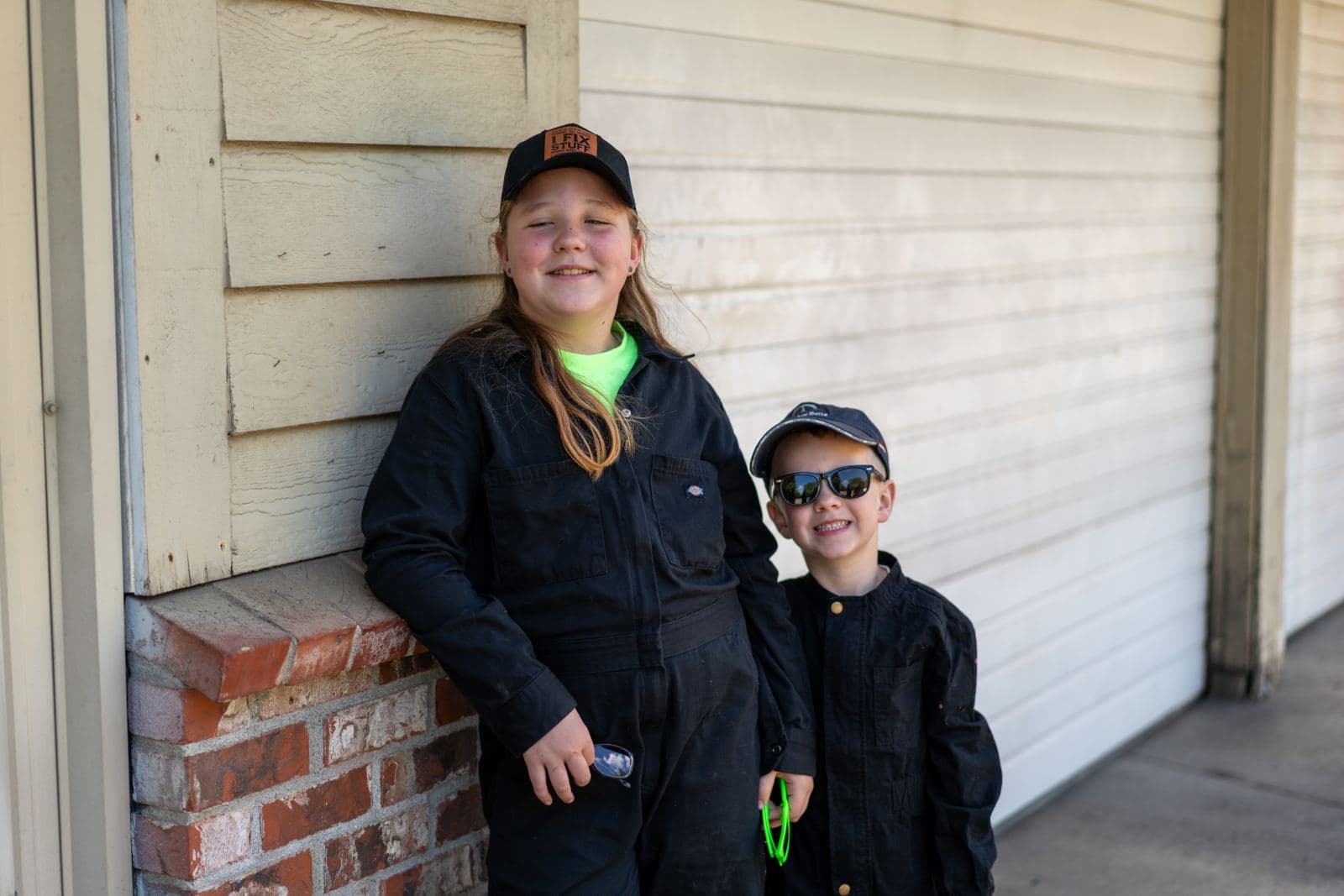 Junior crew members in coveralls outside the shop