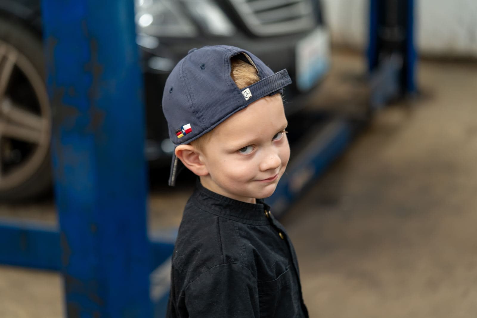 Shop owner teaching a junior crew member under the hood of a Mercedes
